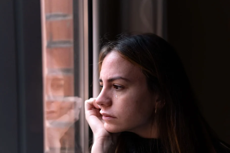 woman looking out window reflection sad