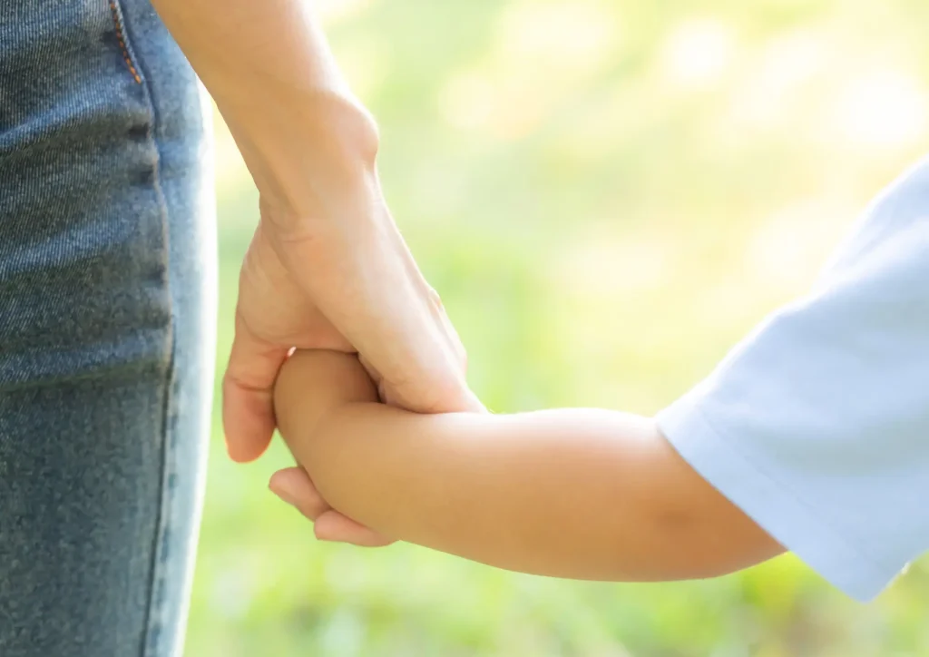 Kind wird an der Hand geführt, Erwachsene Hand
