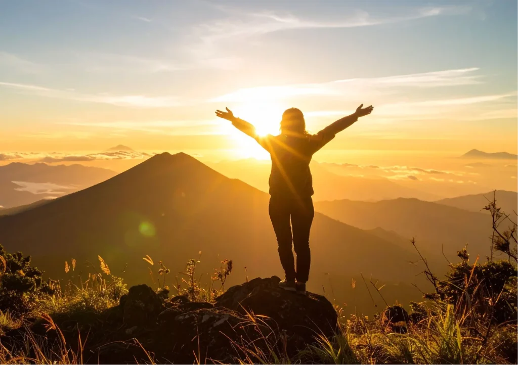 Frau mit ausgebreiteten Armen vor weitem Himmel – Symbol für Freiheit und Selbsterlaubnis